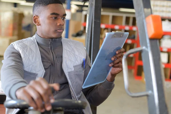 Arbeiter im Logistiklager mit Hilfe einer Gabelstapler-Checkliste — Stockfoto