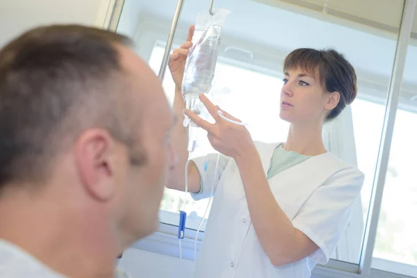 Enfermera revisando sus pacientes perfusión — Foto de Stock