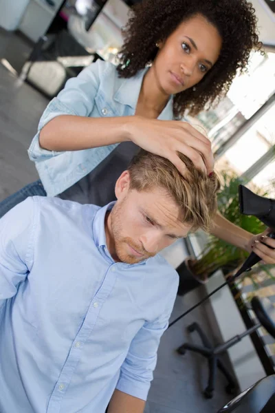 Güzel Kuaför yakışıklı istemcileri saç kurutma — Stok fotoğraf