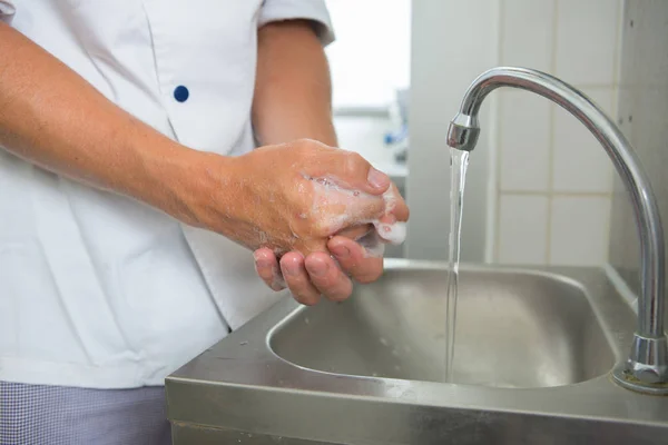 Hombre lavándose las manos en la cocina — Foto de Stock