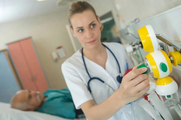 Enfermera cuidando de un paciente mayor — Foto de Stock