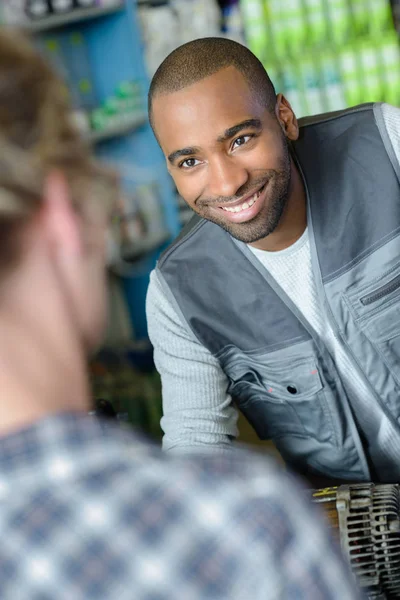 Glimlachend mechanic gesprekken aan klant over auto-onderdeel — Stockfoto