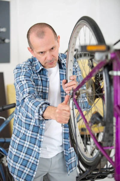 Geschäftsinhaber repariert Fahrrad — Stockfoto