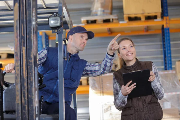 Manager parlando con il suo dipendente nel magazzino — Foto Stock