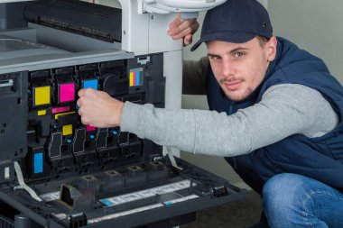 Man replacing ink cartridges in photocopier clipart