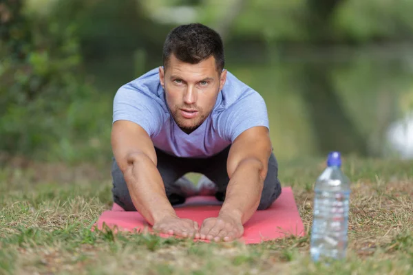 Portrait of man reaching forward on exercise mat — Stock Photo, Image