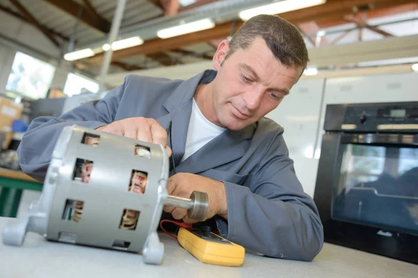 Reparaturbetrieb testet zylindrische Komponente mit Multimeter — Stockfoto