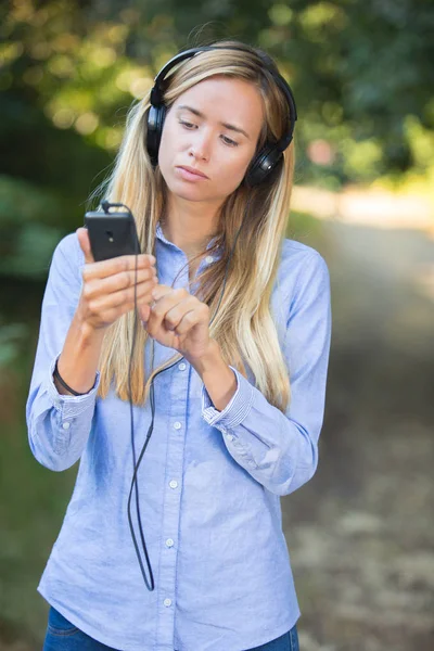 Hermosa mujer escuchando música con auriculares al aire libre —  Fotos de Stock