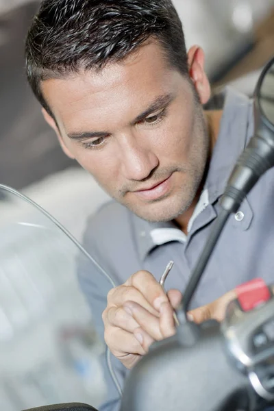 Mechanic working on handlebars of scooter — Stock Photo, Image