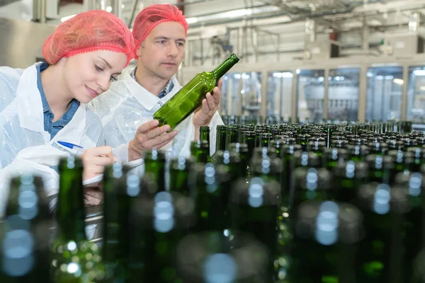 Vrolijke man en vrouw dragen van uniform in de brouwerij rij staan — Stockfoto