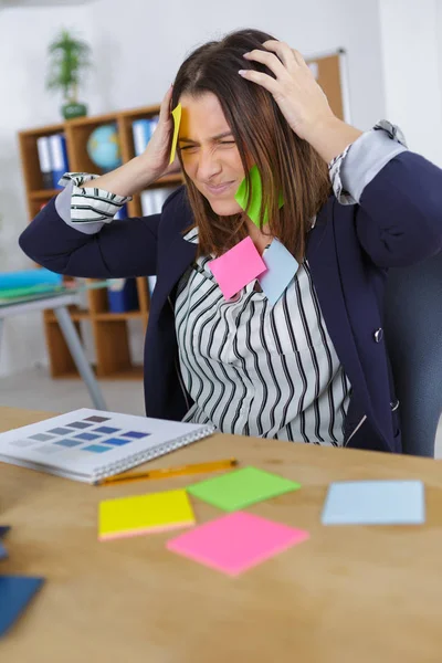 Affärskvinna med massor av påminnelse anteckningar — Stockfoto