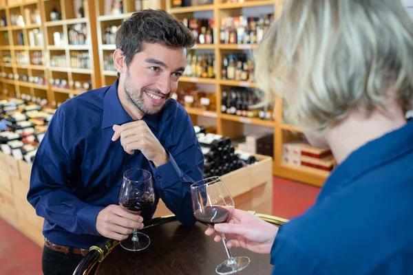 Homme et femme trinquant avec du vin dans un magasin d'alcool — Photo