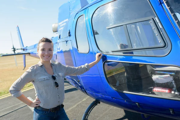 Retrato de mulher em pé por um helicóptero azul — Fotografia de Stock