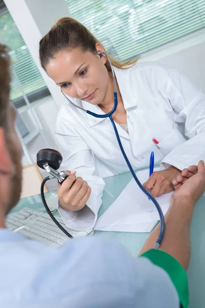 Médico testando a pressão arterial para um paciente sênior — Fotografia de Stock