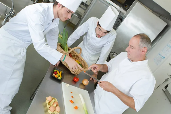 Szakács felügyeletet ellátó gyakornokok főzés — Stock Fotó
