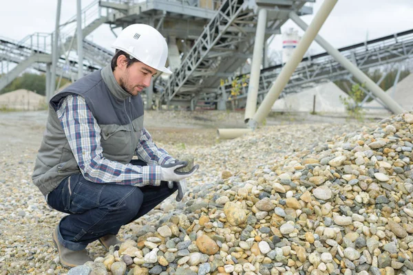 Constructeur vérifiant les cailloux à l'extérieur d'un chantier — Photo