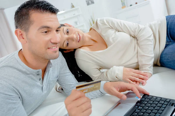 Jovem casal com cartão de crédito e laptop — Fotografia de Stock