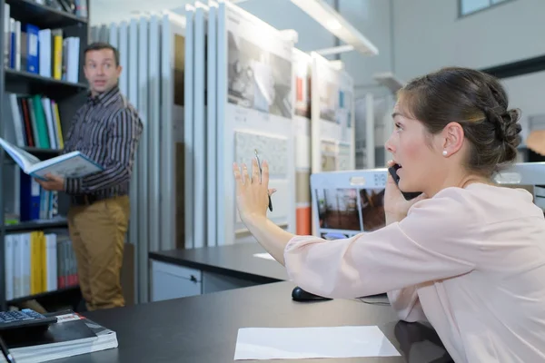 Arbeiterin am Handy diskutiert mit Kollegin — Stockfoto