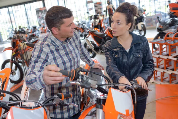 Hombre alegre guapo cerca de su nueva moto hablando con el vendedor — Foto de Stock