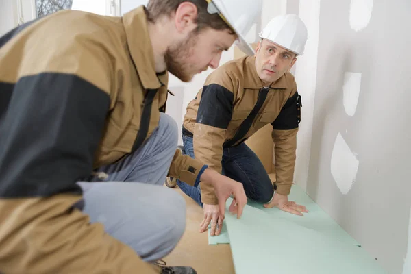 Arbeiter, die Fußböden verlegen und Arbeiter — Stockfoto