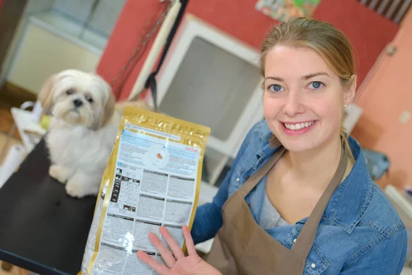 Woman showing packet of dog food — Stock Photo, Image