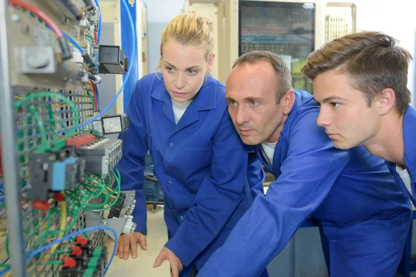 Ausbilder mit zwei angehenden Elektrikern — Stockfoto