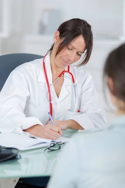 Vrouwelijke arts luisteren naar haar kantoor patientin — Stockfoto