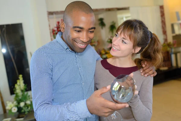 Couple looking at wineglass in store — Stock Photo, Image