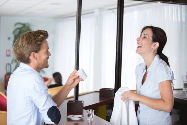 Sorrindo bonito barman masculino dando xícara de café ao cliente — Fotografia de Stock