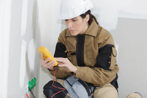Elettricista femminile che installa una presa a muro — Foto Stock