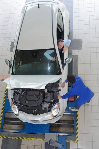 Mecânico e técnico trabalhando juntos para reparar um carro — Fotografia de Stock