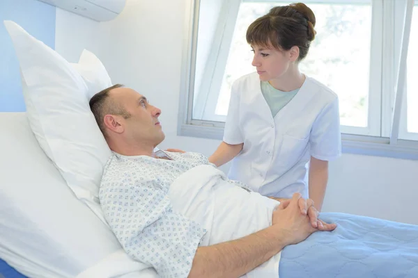 Mannelijke patiënt, praten met vrouwelijke verpleegkundige in de noodsituatieruimte — Stockfoto