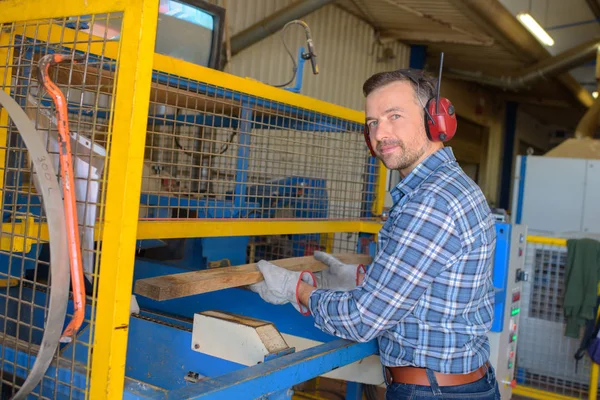 Sawmill employee working with wood tools and machinery — Stock Photo, Image