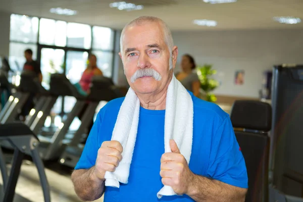 Oudere man poseren in de sportschool — Stockfoto