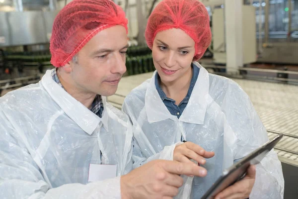 Workers of brewery reading information from the tablet — Stock Photo, Image