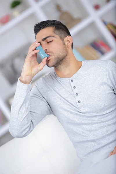 Close-up van jonge man met behulp van astma-inhalator — Stockfoto