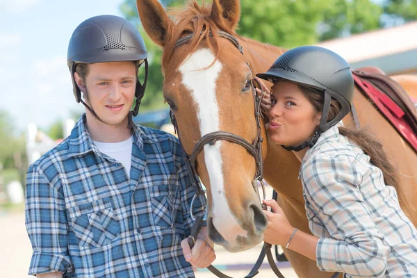 Man met vrouw kussen paard — Stockfoto