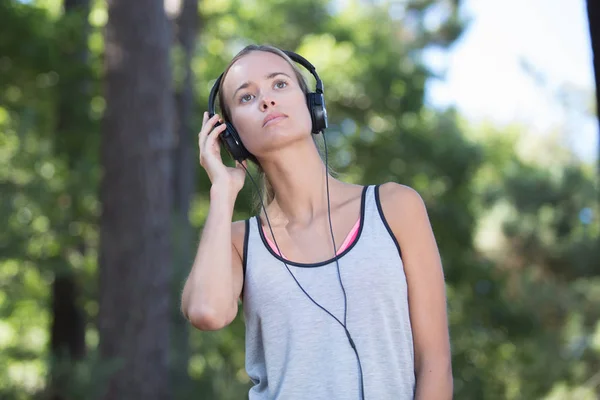 Jong mooi vrouw luisteren naar muziek met hoofdtelefoon — Stockfoto