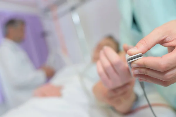 Medische apparaat kit gekoppeld aan de vinger van een patiënt — Stockfoto