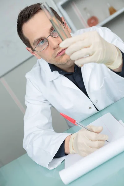 Joven científico en mientras bata de laboratorio — Foto de Stock