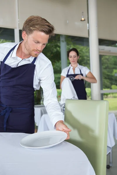 Kelner, organizowanie miejsce ustawienia na stole — Zdjęcie stockowe