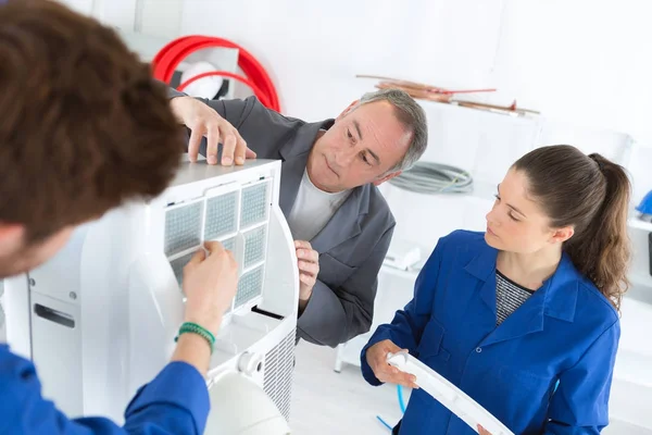 Studenti che imparano la riparazione dell'aria condizionata da un istruttore esperto — Foto Stock