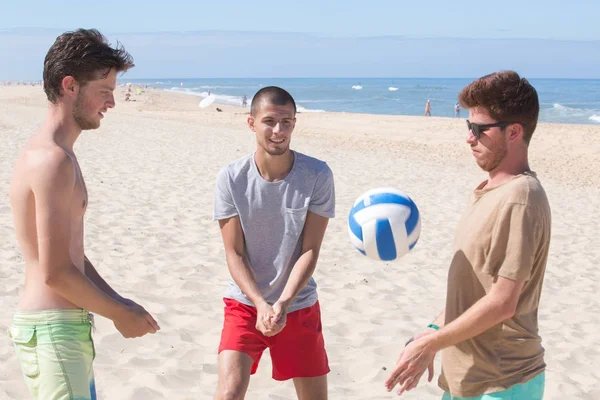 Groupe d'amis jouant avec la balle sur la plage — Photo