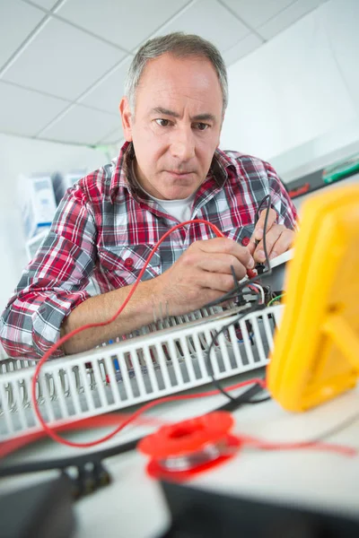 Homem que testa a eletrônica outro observando resultados — Fotografia de Stock