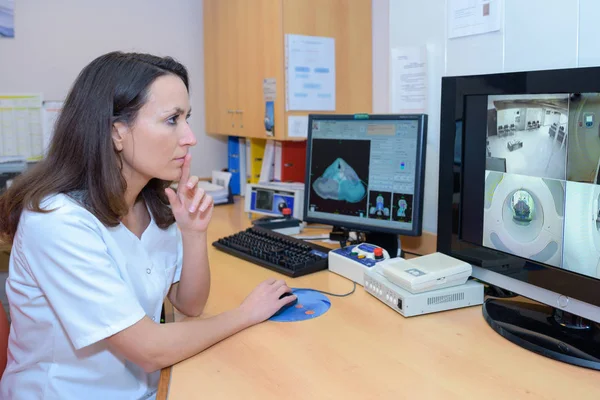 Medical worker looking at imagery on screen — Stock Photo, Image
