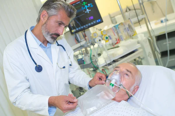 병원에서 남성 환자에 게 산소 마스크를 주는 의사 — 스톡 사진