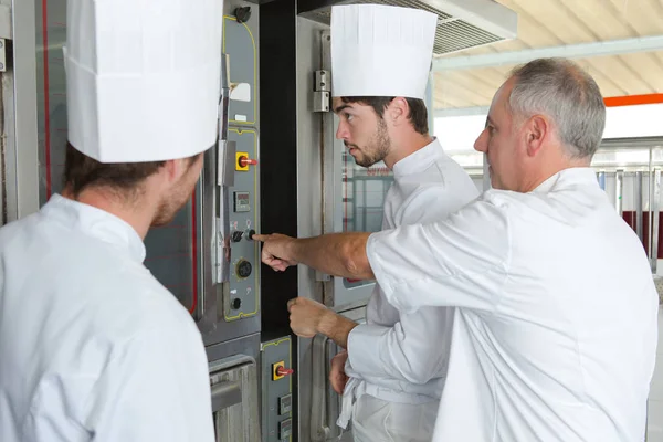 Team di panettieri che cucinano pasta in una cucina commerciale — Foto Stock