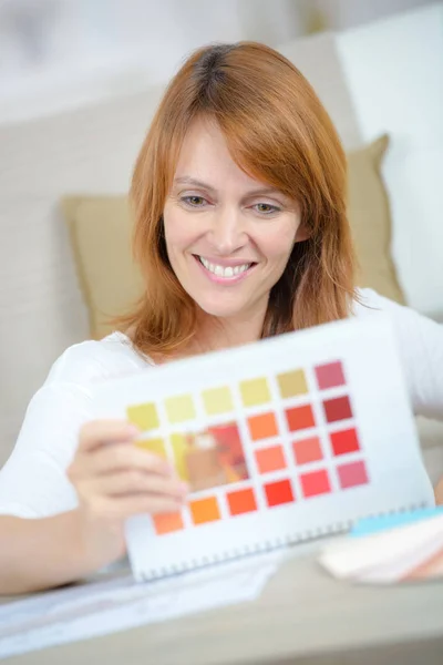 Woman smiling holding color page — Stock Photo, Image