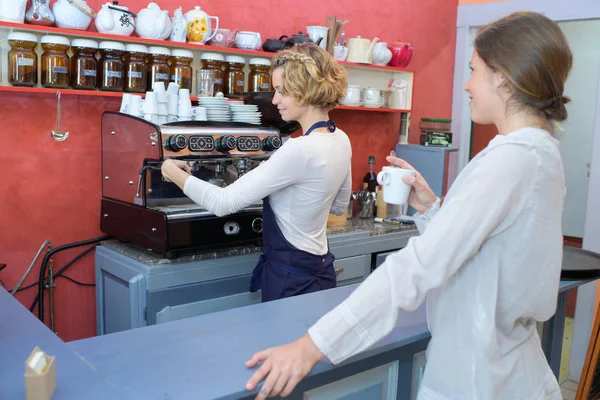 Barista κάνοντας καφές στο μπαρ με θηλυκό πελάτη — Φωτογραφία Αρχείου