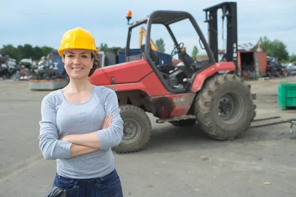 Porträtt av kvinnliga gaffeln lyfta lastbilschaufför i bilskrot — Stockfoto